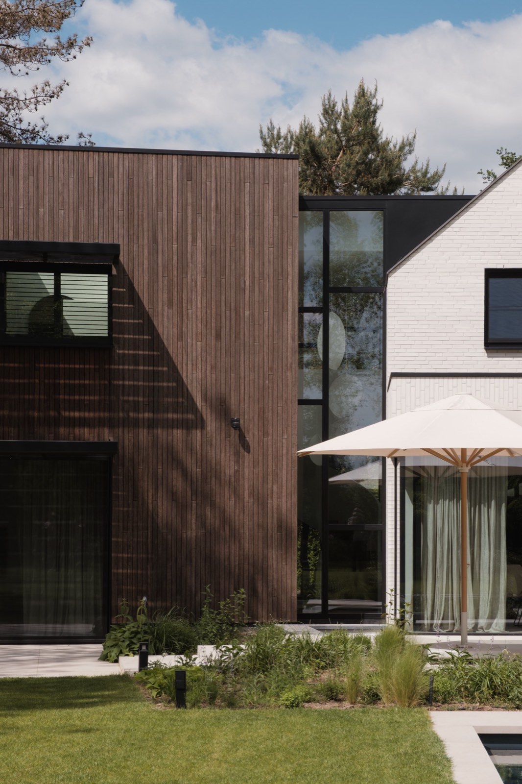 Houten volume tegen het witte metselwerk